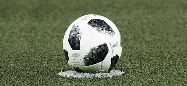 ballon de foot professionnel blanc et noir posé sur gazon